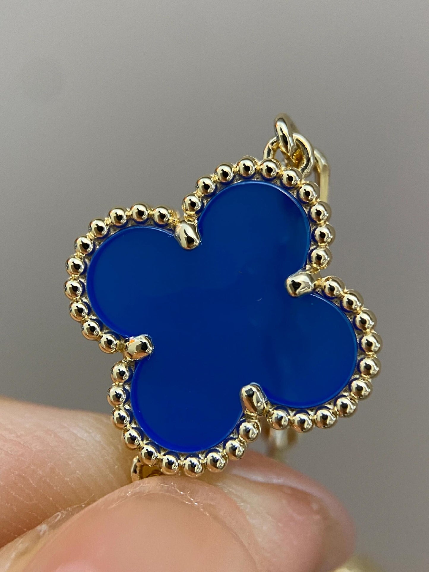 Detailed Close-Up of a Gold-Trimmed Blue Four-Leaf Clover-Shaped Pendant